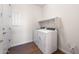 Modern laundry room featuring white washer and dryer, shelf, and light wood-look flooring at 21277 N 272Nd Ave, Buckeye, AZ 85396