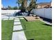 Lush backyard featuring artificial grass, stepping stones and a tranquil waterfall pool at 127 E Pershing Ave, Phoenix, AZ 85022