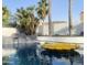 Backyard pool with built-in rock waterfall feature and mature landscaping at 127 E Pershing Ave, Phoenix, AZ 85022