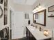 Bathroom featuring a white countertop, dark cabinets, and a framed mirror with decorative wall art at 1347 W Straford Ave, Gilbert, AZ 85233