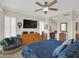 Bedroom featuring wood floors, a ceiling fan, large windows with shutters, and a dresser with a TV at 1347 W Straford Ave, Gilbert, AZ 85233
