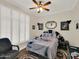 Stylized bedroom with a decorative comforter, white plantation shutters, and a ceiling fan with overhead lighting at 1347 W Straford Ave, Gilbert, AZ 85233