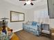 Cozy bedroom featuring a trundle daybed, a golden framed mirror, and light-filled plantation shutters at 1347 W Straford Ave, Gilbert, AZ 85233