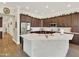 A spacious kitchen with a large island, stainless steel appliances, and dark wood cabinets at 1347 W Straford Ave, Gilbert, AZ 85233