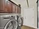 Laundry room with a front-load washer and dryer set, and lots of storage cabinets above at 1347 W Straford Ave, Gilbert, AZ 85233