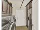 Laundry room featuring a side-by-side washer and dryer set with storage cabinets and a stainless steel fridge at 1347 W Straford Ave, Gilbert, AZ 85233