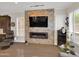 Modern living room features a stone wall fireplace, plush seating, and shuttered windows at 1347 W Straford Ave, Gilbert, AZ 85233