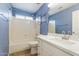 Stylish bathroom featuring a modern vanity with white marble countertop, blue walls, and a shower-tub combination at 1520 E Flint St, Chandler, AZ 85225