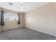 Well-lit bedroom with neutral walls, plush gray carpet, and a ceiling fan at 1520 E Flint St, Chandler, AZ 85225