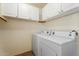 Functional laundry room equipped with modern washer and dryer units, with ample cabinetry space for storage at 1520 E Flint St, Chandler, AZ 85225