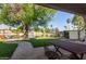 Scenic backyard with lake view, artificial turf, mature landscaping, and patio area at 3109 N Meadow Dr, Avondale, AZ 85392