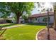Beautiful backyard featuring a lush lawn, mature trees, and patio seating area at 3109 N Meadow Dr, Avondale, AZ 85392