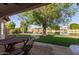 Spacious backyard with a covered patio, lush lawn, mature trees, and waterfront access at 3109 N Meadow Dr, Avondale, AZ 85392