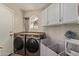 Laundry room with a new washer and dryer, a small window, and white cabinets at 3109 N Meadow Dr, Avondale, AZ 85392
