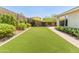 Spacious backyard with artificial turf, manicured landscaping, and a brick-paved walkway along the perimeter at 5962 E Abraham Ln, Phoenix, AZ 85054