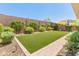 Beautiful backyard features a vibrant lawn area, lush landscaping, and a charming brick pathway at 5962 E Abraham Ln, Phoenix, AZ 85054