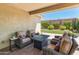 Cozy covered patio with comfortable seating, a modern fire pit, and a view of the beautifully landscaped yard at 5962 E Abraham Ln, Phoenix, AZ 85054