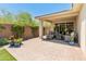 Covered patio with brick flooring, outdoor seating, fire pit, and access to a well-manicured backyard at 5962 E Abraham Ln, Phoenix, AZ 85054