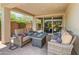 Covered patio showcasing comfortable outdoor seating, a fire pit, and views of the landscaped backyard at 5962 E Abraham Ln, Phoenix, AZ 85054