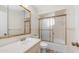 A full bathroom featuring a shower with glass doors and gold trim, toilet, vanity and mirror at 6258 E Duncan St, Mesa, AZ 85205