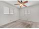 A sunlit bedroom with a wooden ceiling fan and two windows that bring in natural light at 6258 E Duncan St, Mesa, AZ 85205