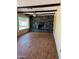 This living room features dark wood laminate flooring, dark ceiling beams, and a stone fireplace at 6258 E Duncan St, Mesa, AZ 85205