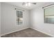 This bedroom offers neutral carpet, a ceiling fan, and window that provides natural light at 10363 W Rosewood Ln, Peoria, AZ 85383