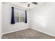 This bedroom offers neutral carpet, a ceiling fan, and a window that provides natural light at 10363 W Rosewood Ln, Peoria, AZ 85383