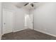 This bedroom offers neutral carpet, a ceiling fan, and a door leading to another room at 10363 W Rosewood Ln, Peoria, AZ 85383