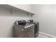 This laundry room features front load washer and dryer with shelving for storage at 10363 W Rosewood Ln, Peoria, AZ 85383