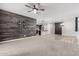 Open concept living room featuring a rustic wood accent wall and barndoor in the distance at 10363 W Rosewood Ln, Peoria, AZ 85383