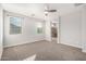 Bright primary bedroom features neutral carpet, windows, and an ensuite bathroom at 10363 W Rosewood Ln, Peoria, AZ 85383