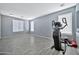 Spacious exercise room with gray wood-look floors, neutral paint, and large windows providing ample natural light at 10775 W Davis Ln, Avondale, AZ 85323