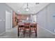 Open dining area with view into kitchen, complete with table and modern lighting at 10775 W Davis Ln, Avondale, AZ 85323