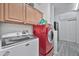 This laundry room features a red dryer, white washing machine, and storage cabinets at 10775 W Davis Ln, Avondale, AZ 85323