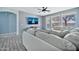 Bright living room featuring a large comfortable couch and entertainment center with an arched doorway at 10775 W Davis Ln, Avondale, AZ 85323