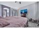 This main bedroom features a ceiling fan, light grey walls, ensuite, and a television at 10775 W Davis Ln, Avondale, AZ 85323