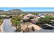 Aerial view of a desert home with lush landscaping, a tile roof, and stunning mountain views at 11099 E Desert Vista Dr, Scottsdale, AZ 85255