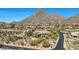 Aerial view of community desert home nestled amongst cacti, mature trees, and mountains at 11099 E Desert Vista Dr, Scottsdale, AZ 85255