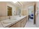 Bright bathroom featuring a long vanity with tiled countertop and floors with a doorway leading to bedroom at 11099 E Desert Vista Dr, Scottsdale, AZ 85255
