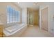 Bathroom featuring a bathtub with tile surround, walk in shower, carpet floors and a glass-blocked window at 11099 E Desert Vista Dr, Scottsdale, AZ 85255