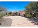 Front exterior featuring desert landscaping, a large driveway, and an attached garage at 11099 E Desert Vista Dr, Scottsdale, AZ 85255