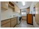 Laundry room with a washer and dryer, light cabinets, a sink and tile flooring at 11099 E Desert Vista Dr, Scottsdale, AZ 85255