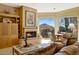 Comfortable living room with fireplace, built-in cabinets, and scenic views of the surrounding desert mountain landscape at 11099 E Desert Vista Dr, Scottsdale, AZ 85255