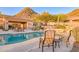 Community pool with covered seating and mountain views, surrounded by desert flora at 11099 E Desert Vista Dr, Scottsdale, AZ 85255