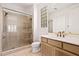 Bathroom with tile shower, glass surround, single sink vanity, and a glass block accent wall at 11187 E De La O Rd, Scottsdale, AZ 85255