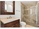 Bathroom with a tile shower, glass surround, and stylish vanity mirror with detailed wood frame at 11187 E De La O Rd, Scottsdale, AZ 85255