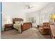 Well-lit bedroom featuring a ceiling fan, sitting area, and large windows with plantation shutters at 11187 E De La O Rd, Scottsdale, AZ 85255
