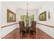 Formal dining room featuring a glass table, wood flooring, and designer chandelier at 11187 E De La O Rd, Scottsdale, AZ 85255