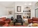 Inviting living room featuring a stone fireplace, custom shelving, and comfortable seating at 11187 E De La O Rd, Scottsdale, AZ 85255